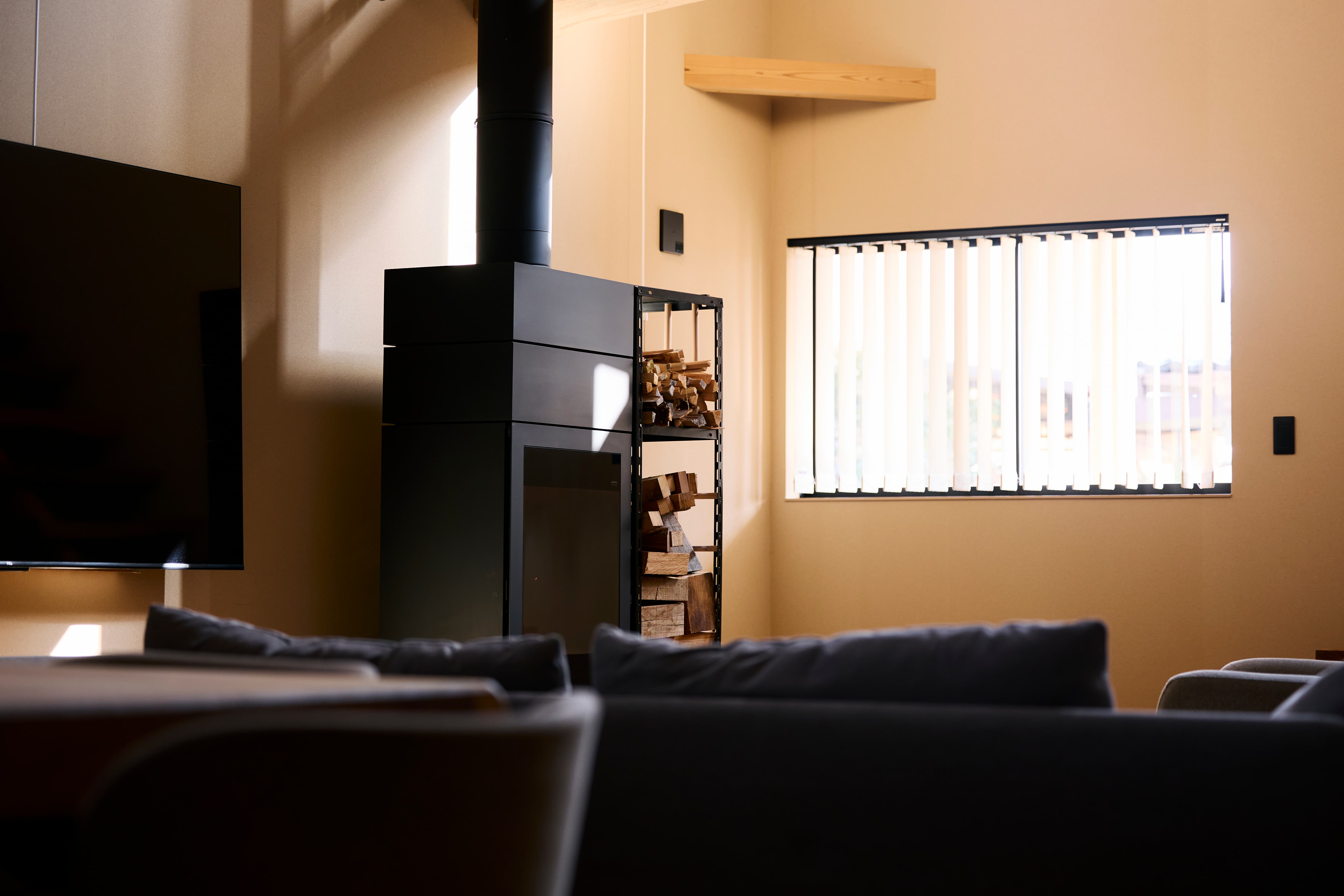 光と影が入る室内と薪ストーブ